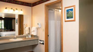 A bathroom with a sink, mirror, and shower curtain.