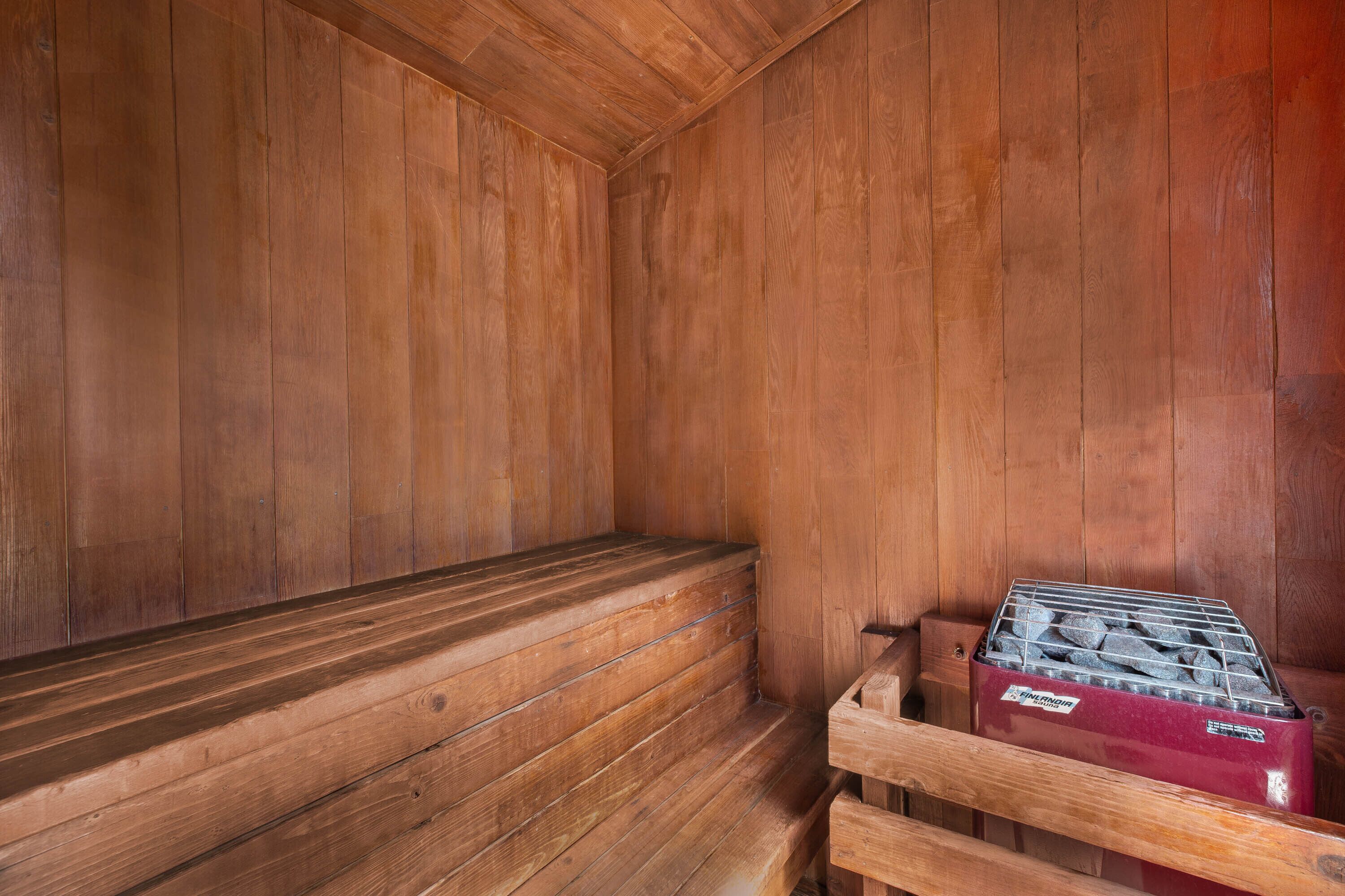 A sauna room with wooden walls and benches.