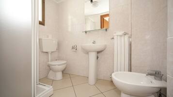 A modern bathroom with a toilet, sink, and shower.