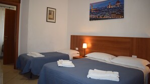 A hotel room with two beds, a nightstand with a lamp, and a painting of a cityscape on the wall. - Hotel Dalmazia (Florence)