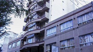 Un hotel de varios pisos con balcones, ventanas amplias y un cartel que indica que es el Hotel San Remo.