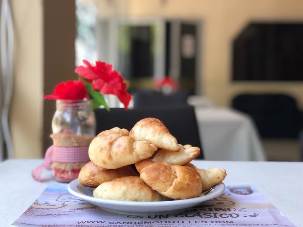 Une assiette de croissants sur une table, avec un menu placé en dessous.