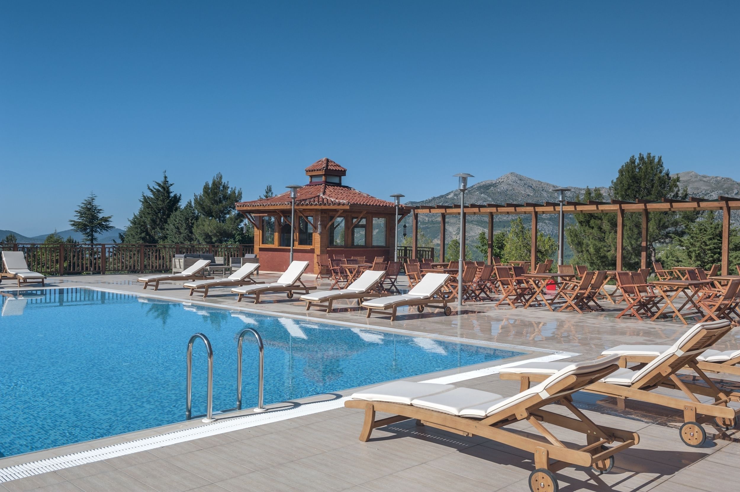 Una piscina cubierta, una piscina al aire libre, sombrillas, tumbonas