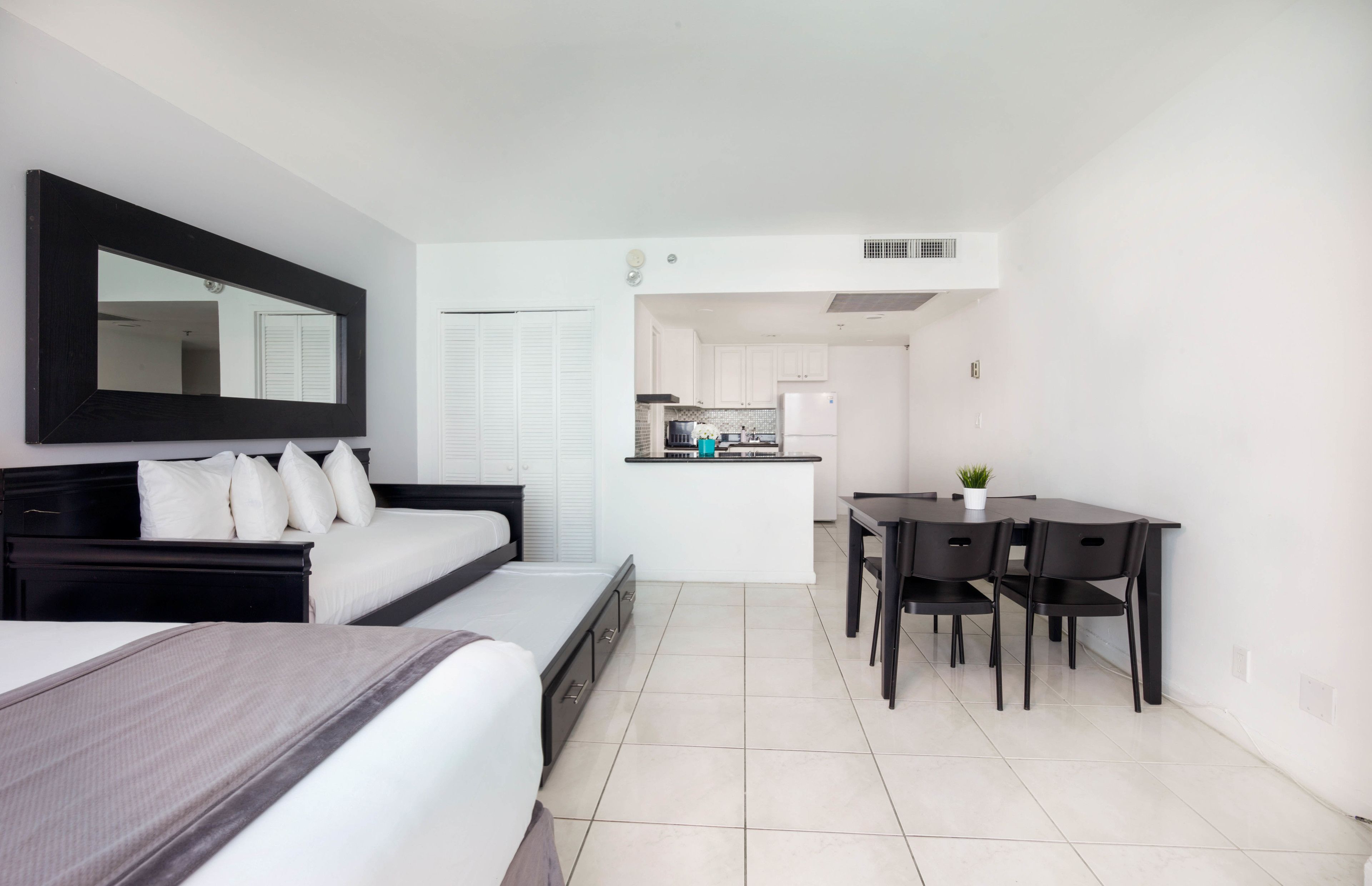 Une chambre d’hôtel moderne dotée d’un grand lit, d’un bureau et d’une kitchenette.