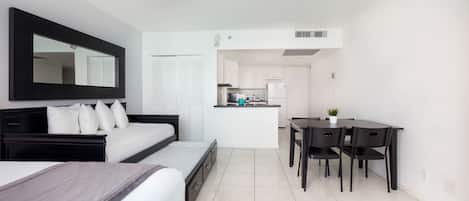Une chambre d’hôtel moderne dotée d’un grand lit, d’un bureau et d’une kitchenette.
