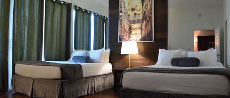 Habitación de hotel con dos camas, un espejo grande y un cuadro en la pared.