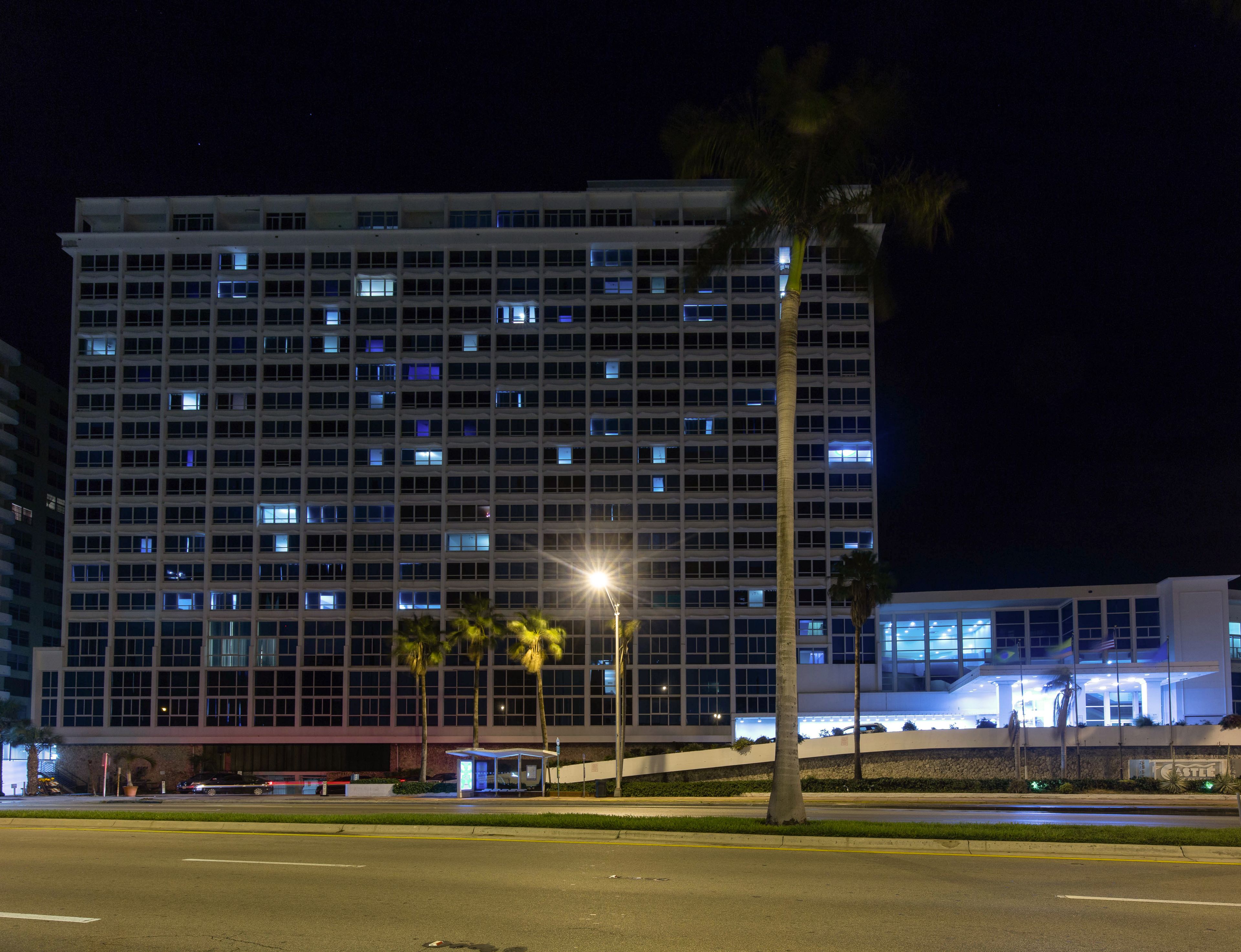 Un hotel de varios pisos con un diseño moderno, que cuenta con numerosos ventanales y una entrada destacada con porche cubierto.