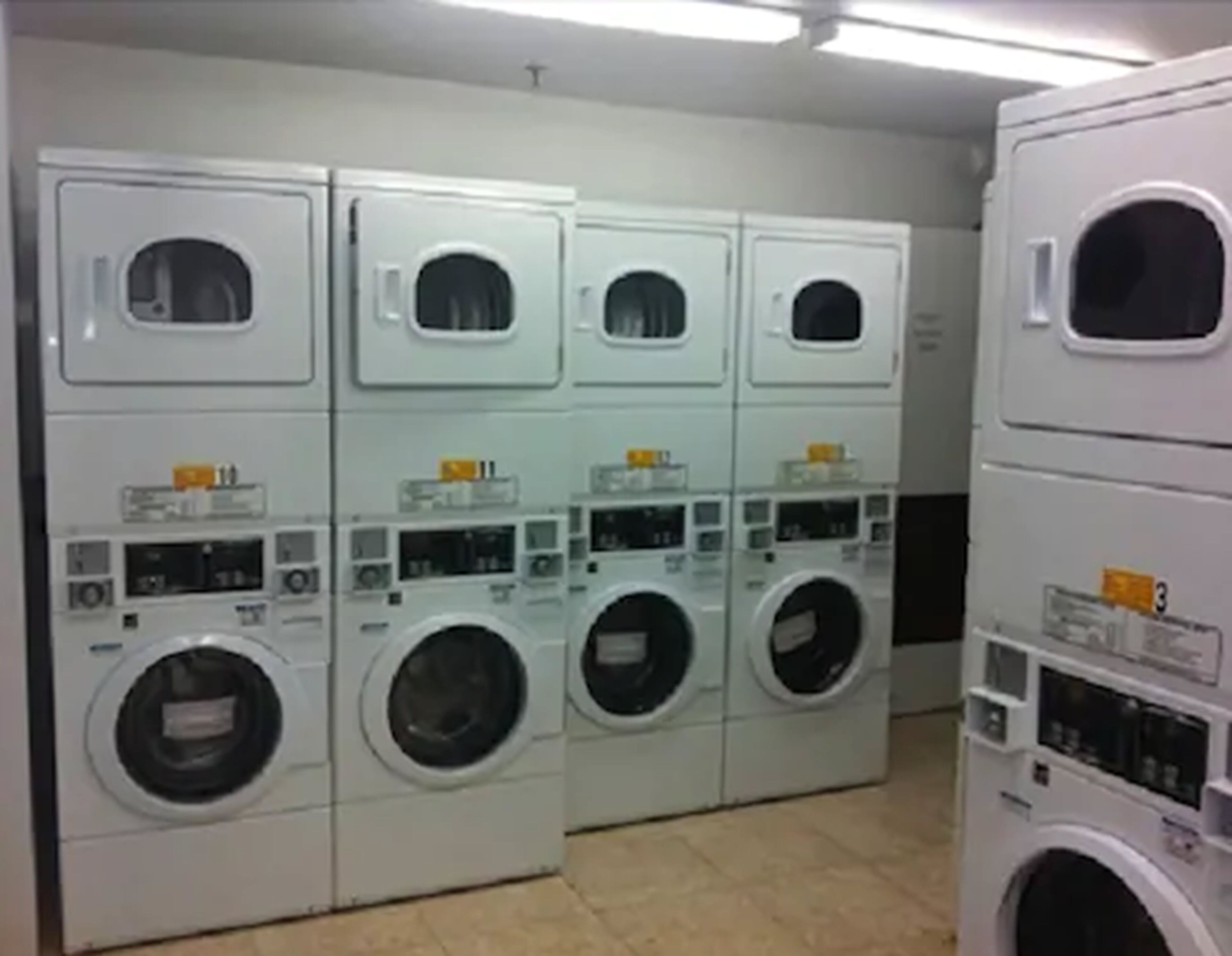 A laundry facility with multiple rows of stacked washing machines.