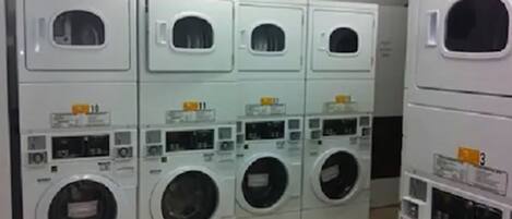 A laundry facility with multiple rows of stacked washing machines.