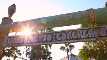 Une pancarte en bois portant l’inscription « BIENVENUE À CONCHLAND » et entourée d’une corde.