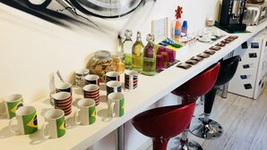 A kitchen counter with various mugs, bottles, and a coffee machine. - Toledo station Bed & breakfast (Naples)