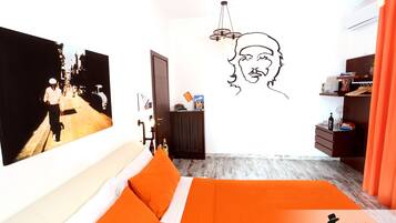 Quarto moderno com cama, TV na parede, obra de arte com silhueta de cabeça e piso de madeira.