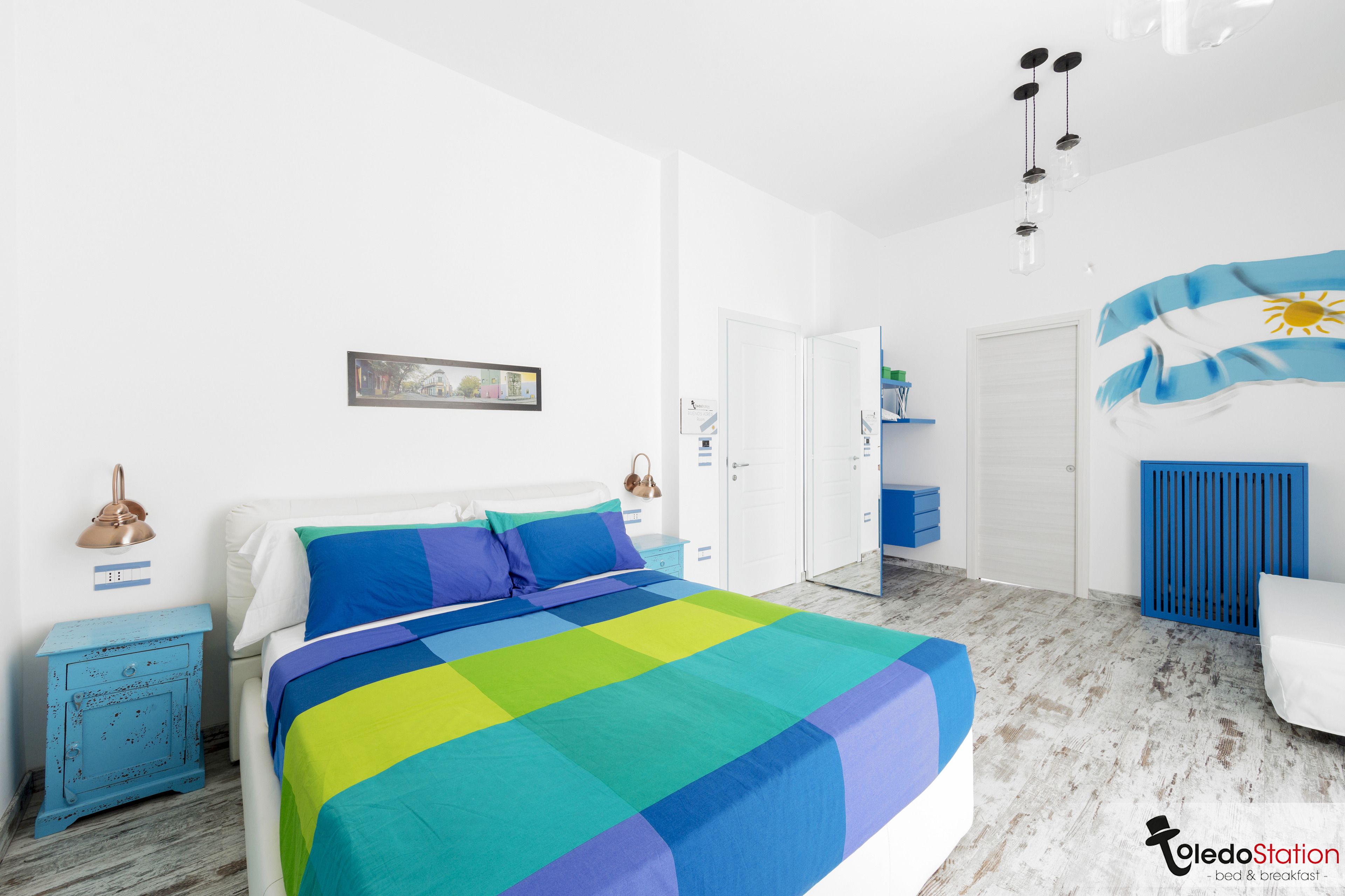 A bedroom with a bed, a nightstand, a dresser, and a wardrobe.