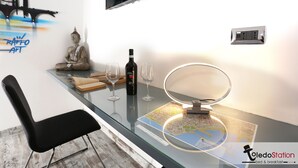 A modern room with a glass table, a Buddha statue, a bottle, and glasses. - Toledo station Bed & breakfast (Naples)