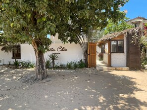Un edificio con un letrero que dice 'Villa Chic' y una estructura de madera con techo de paja.