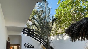 A courtyard with a staircase, a bench, and a wall with 'Villa Chic' signage. - Villa Chic Pousada (Jijoca de Jericoacoara)
