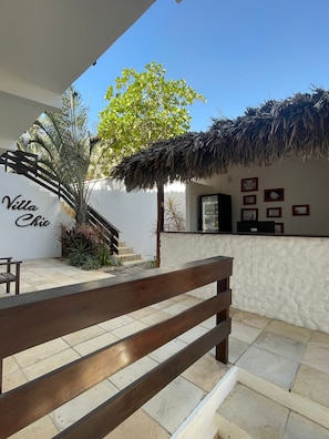 Eine Villa mit Strohdach, einer Treppe und einem Empfangstresen mit Bilderrahmen.