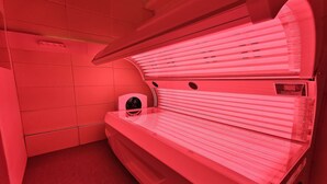 A tanning bed in a room with red lighting. - Inn Cube Ximen (Taipei)