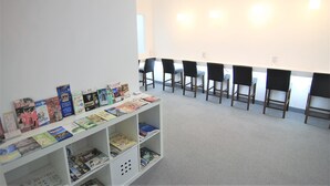 A library with bookshelves and chairs arranged for reading. - Inn Cube Ximen (Taipei)