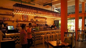 A bar area with a counter, stools, and a variety of bottles on shelves. - The Mesui Hotel (Kuala Lumpur)
