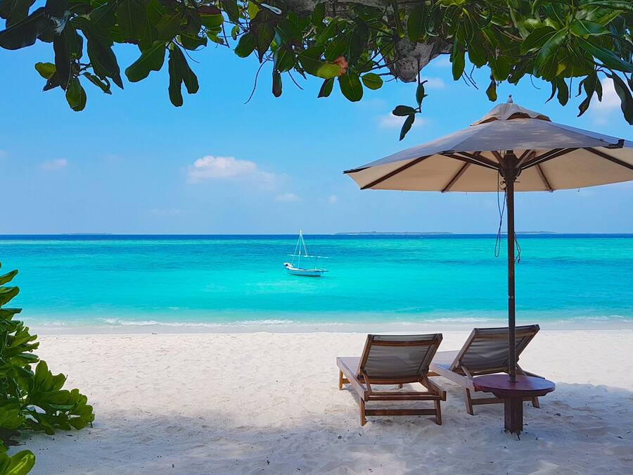 Pantai pribadi, pasir putih, kursi berjemur, dan payung pantai