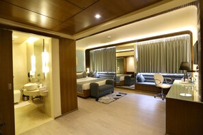 Una habitación de hotel moderna con una cama grande, un sofá, un escritorio y un baño.