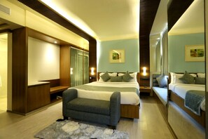 Una habitación de hotel moderna con una cama grande, un sofá, un escritorio y un espejo.