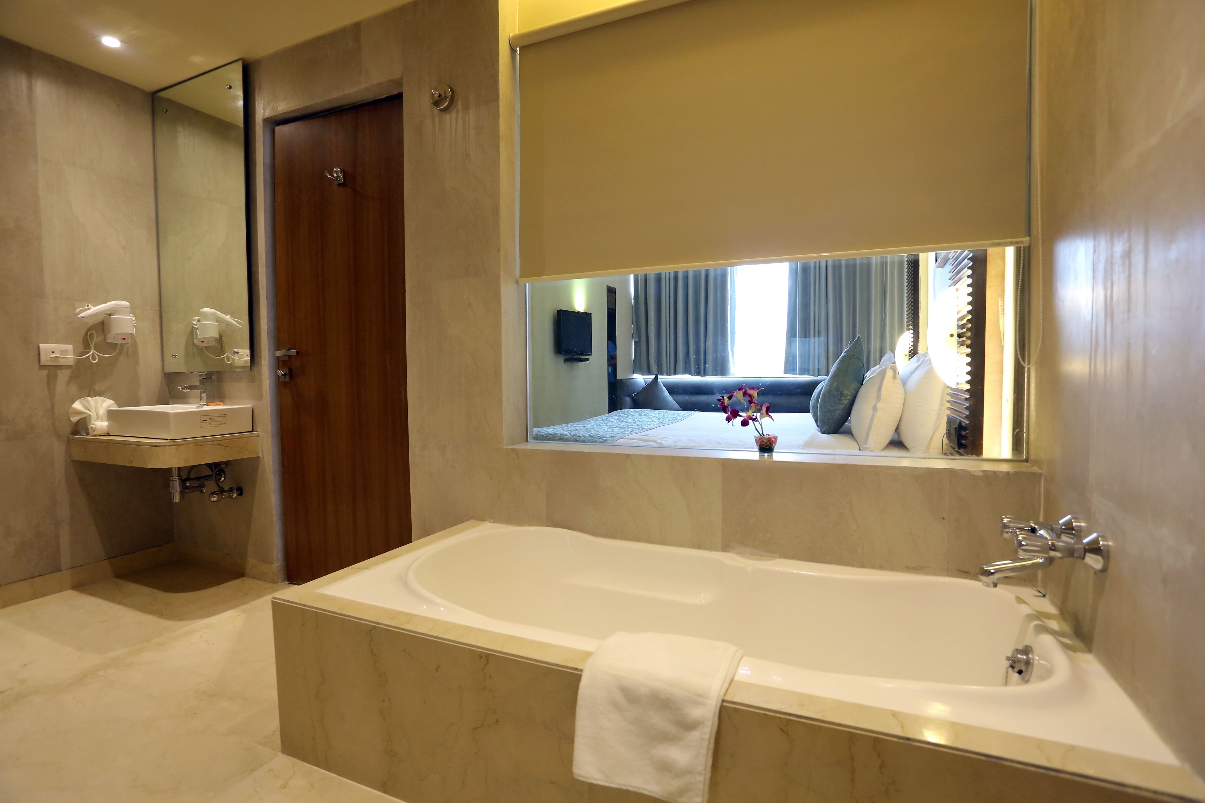 A modern bathroom with a large bathtub, a vanity with a mirror, and a shower area.