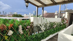 A rooftop garden with a bamboo trellis, various plants, and flowers, and a sign that reads "HART BELLE". - Armenian Suite (George Town)