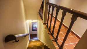 A staircase with wooden steps and a handrail, leading to a door with a window. - Armenian Suite (George Town)