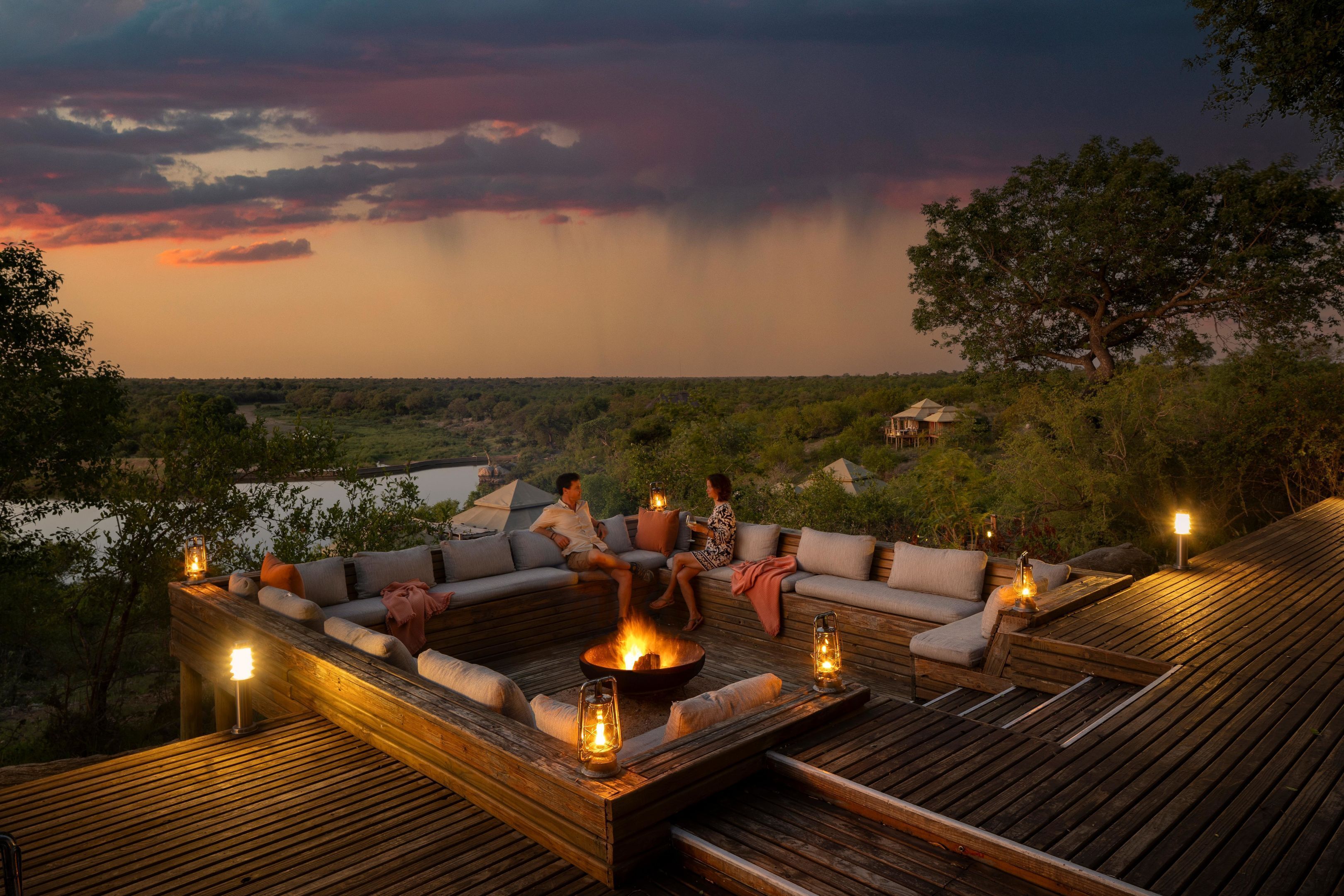 A deck with a fire pit, seating, and lanterns.
