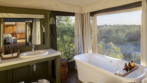 Un bagno moderno con una vasca da bagno ampia, un lavabo doppio e uno specchio grande.
