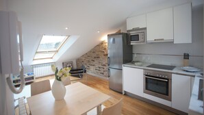 Una cocina moderna con pared de piedra, tragaluces y electrodomésticos de acero inoxidable.