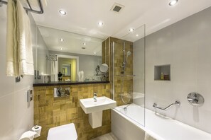 A modern bathroom with a glass-enclosed shower, a white sink, and a bathtub. - Holiday Inn London - Watford Junction by IHG (Watford)