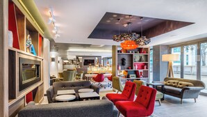 A modern living room with a television, sofas, and a patterned rug. - Holiday Inn London - Watford Junction by IHG (Watford)