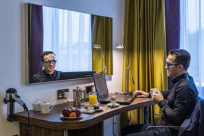 A hotel room with a desk, laptop, coffee cup, and breakfast items. - Holiday Inn London - Watford Junction by IHG (Watford)