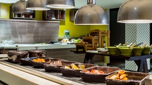 A buffet area with multiple food containers and a variety of dishes. - Holiday Inn London - Watford Junction by IHG (Watford)