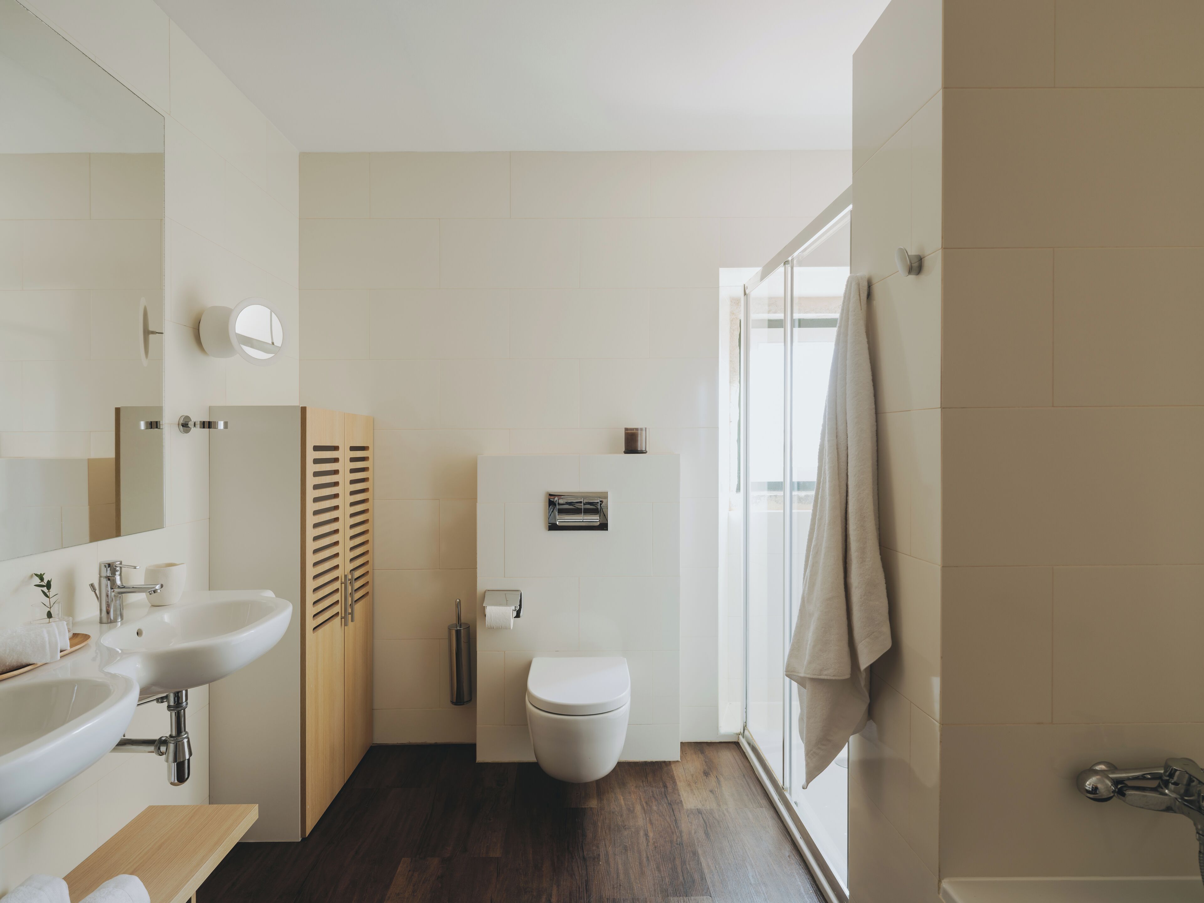A modern bathroom with a sink, toilet, and shower area.