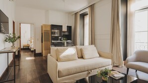 Una sala de estar moderna con un sofá, una mesa de centro y un comedor con una cocina al fondo.