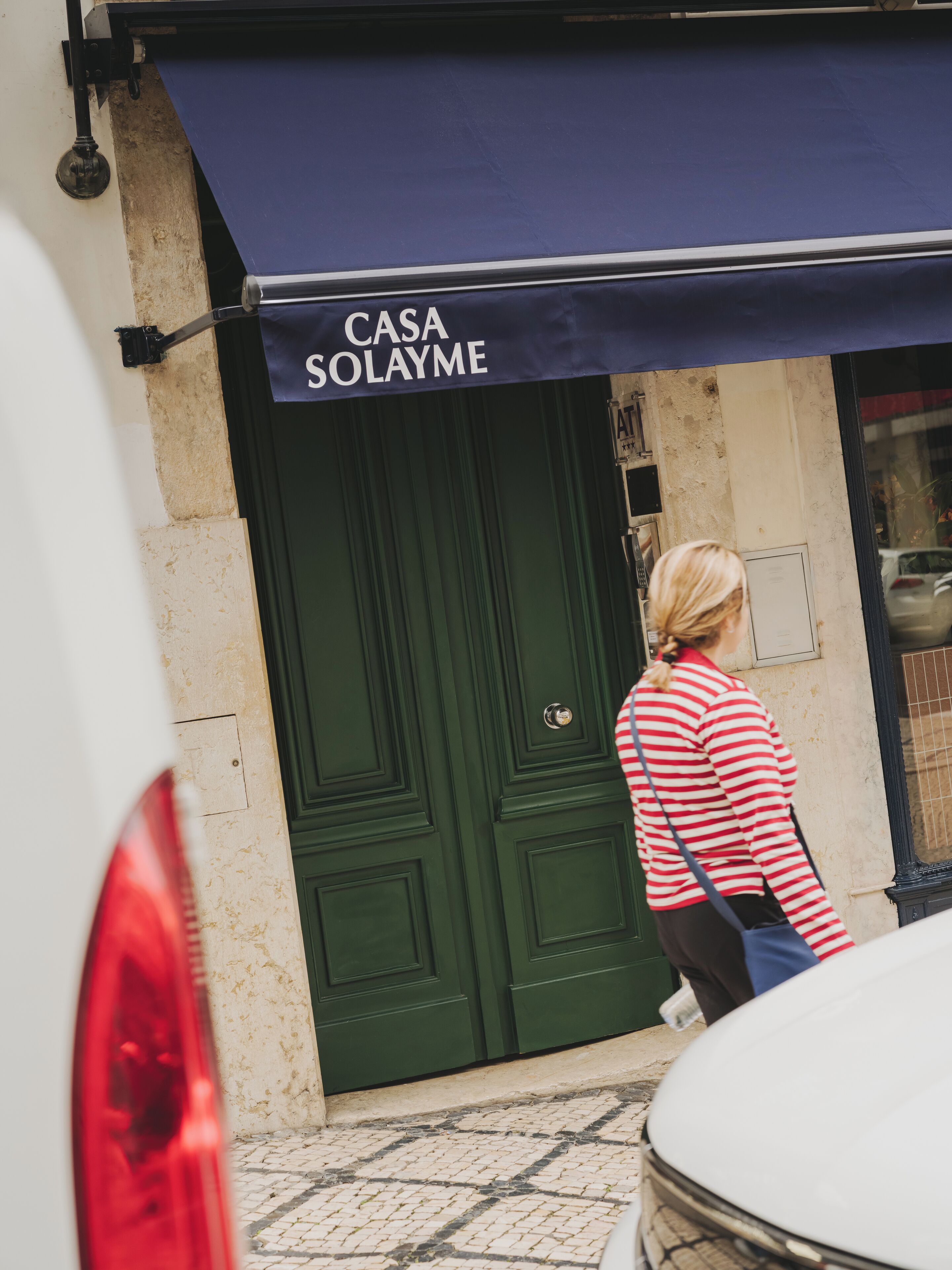 A building with a green door and a sign reading "CASA SOLAYME".