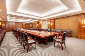Une salle de conférence dotée d’une longue table et de chaises, équipée de microphones et recouverte d’un tapis.