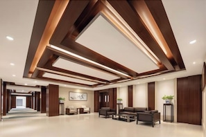 A modern lobby with a high ceiling, recessed lighting, and a seating area with sofas and a coffee table. - Petroleum Hotel (Yulin)