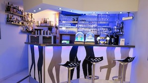 Eine Bar mit Regalen voller Flaschen, Gläsern und einer Registrierkasse.