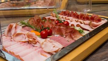 A charcuterie board with various meats and vegetables.