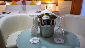 Eine Minibar mit einer Champagnerflasche und zwei Gläsern auf einem Tisch im Hotelzimmer.