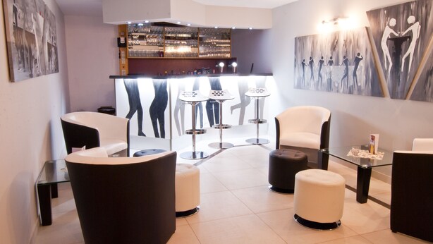 Ein stilvoller Lounge-Bereich mit Bar, Sitzgelegenheiten und Kunstwerken an den Wänden.