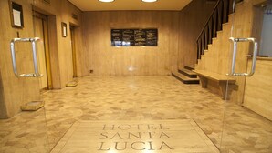 A hotel lobby with a polished stone floor, a staircase, and a sign reading "HOTEL SANTA LUCIA." - Hotel Santa Lucia (Santiago)