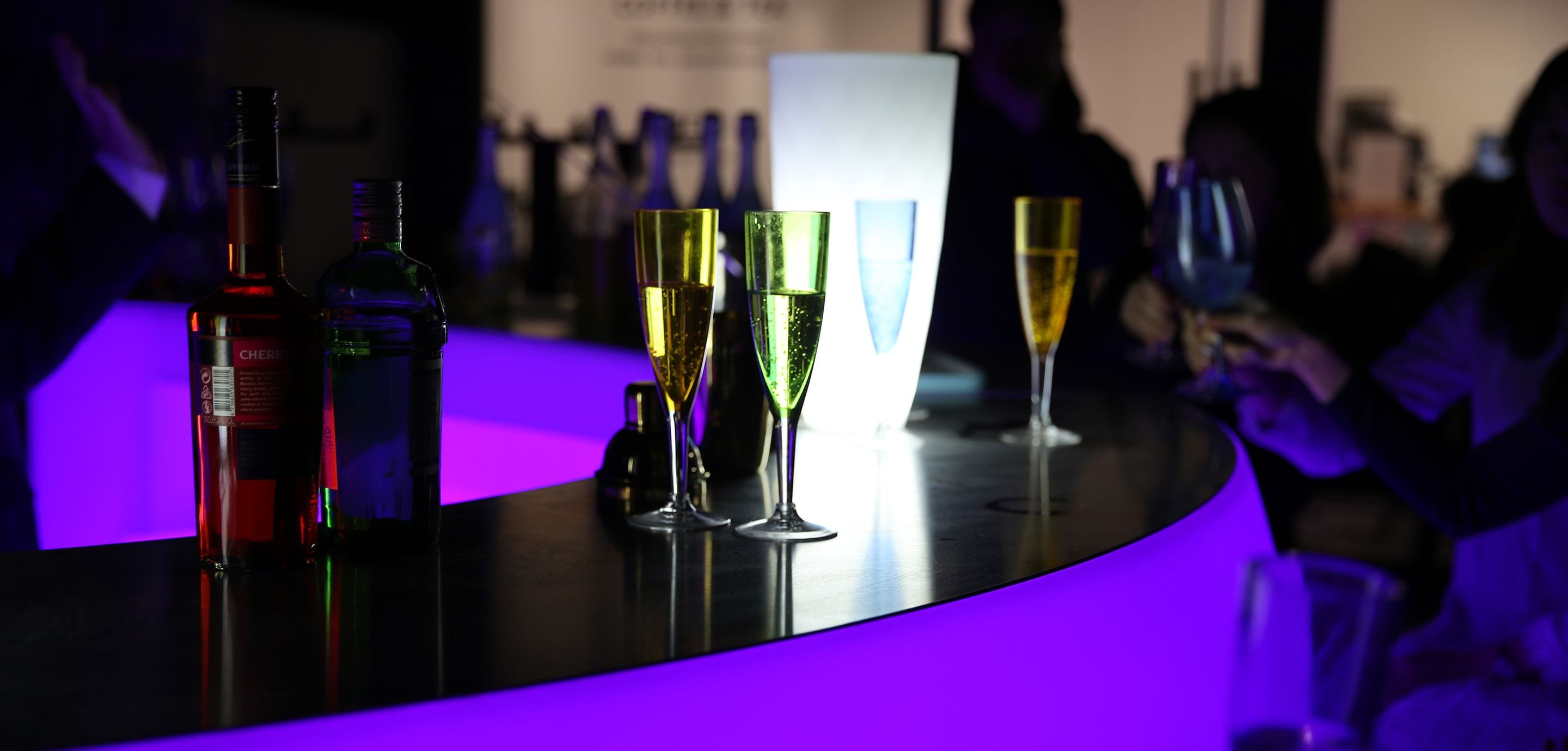 Un espace bar avec des bouteilles et des verres disposés sur une surface réfléchissante.