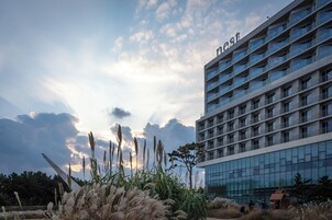 Un hôtel moderne avec une façade en verre et de nombreux balcons.