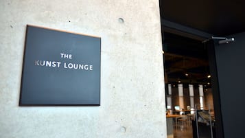 Une enseigne sur un mur, portant l’inscription « THE KUNST LOUNGE ».